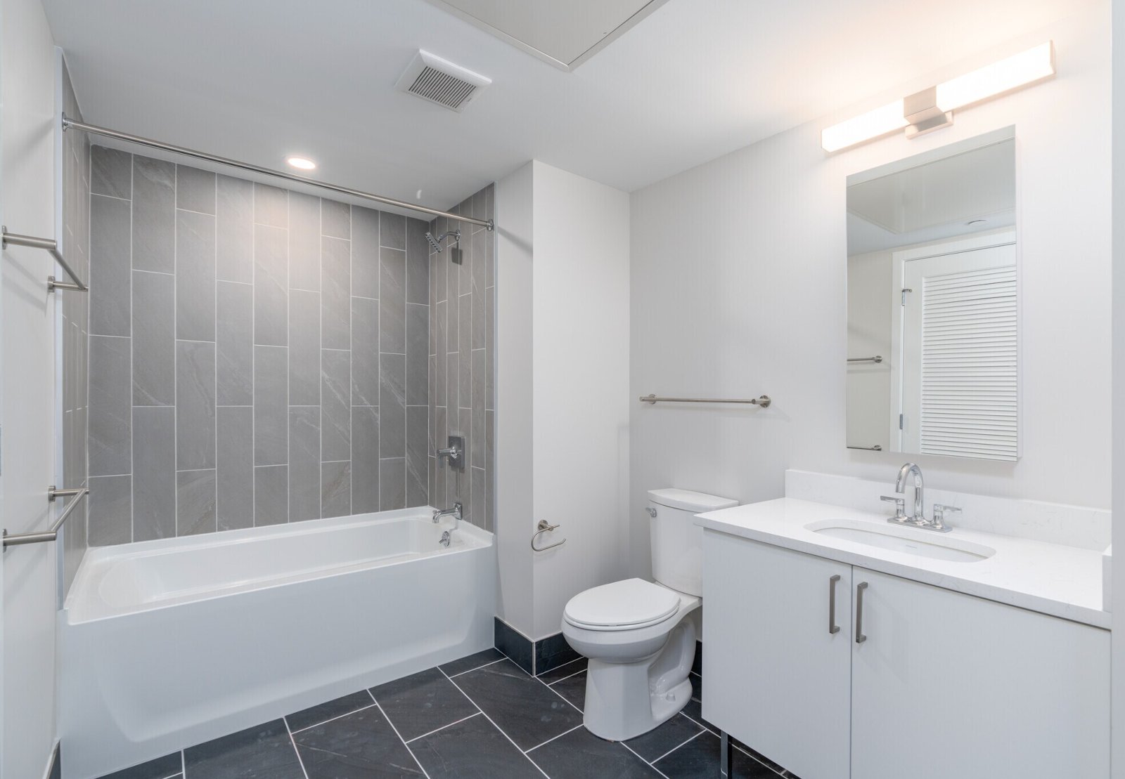 Bathroom with tub, shower, and tile surround, no people