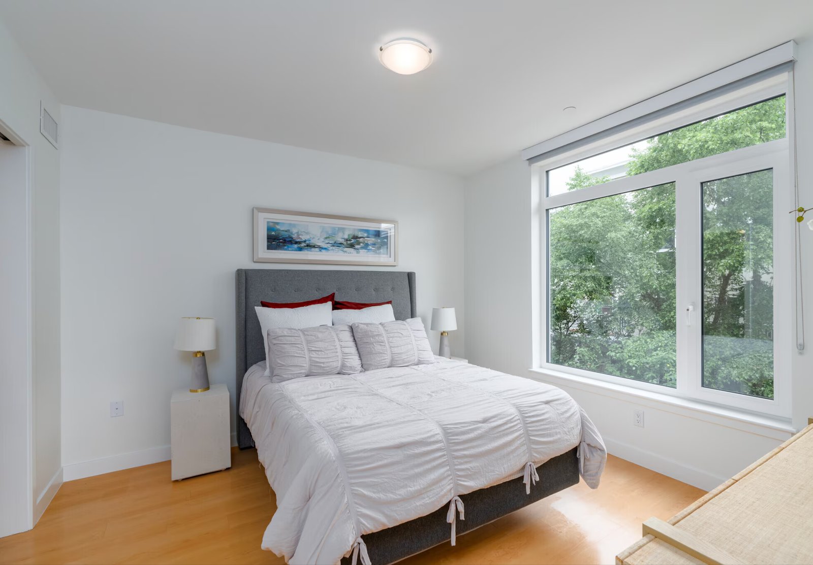 Furnished primary bedroom with upholstered headboard, no people